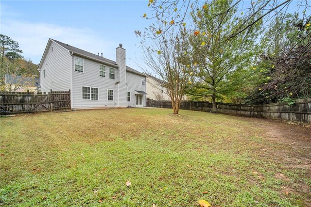 rear view of property featuring a yard