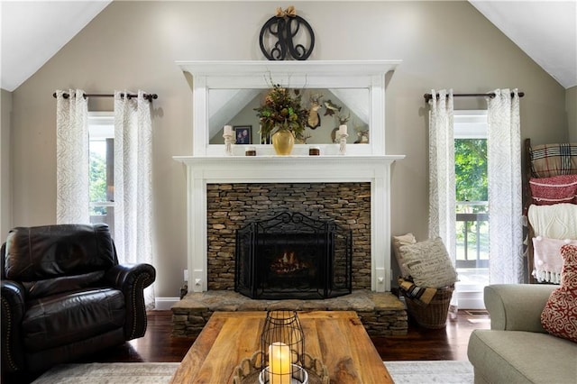 living room with vaulted ceiling, a fireplace, and hardwood / wood-style floors