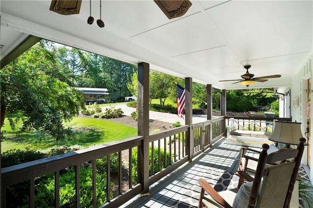 wooden terrace with a yard and ceiling fan