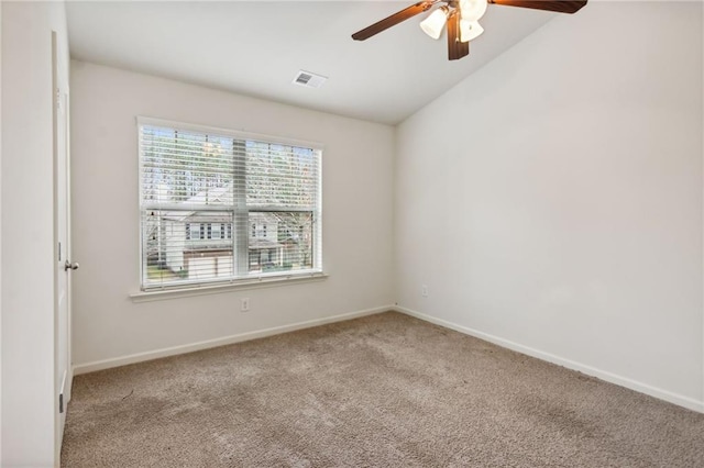 spare room featuring visible vents, baseboards, carpet, and vaulted ceiling