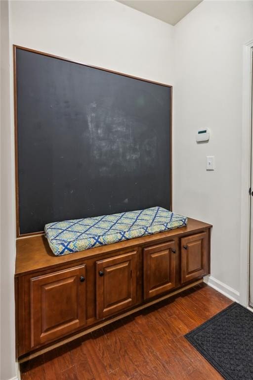 interior space with baseboards and dark wood-style flooring