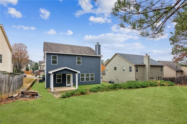 back of house with fence, central air condition unit, a lawn, a chimney, and a patio