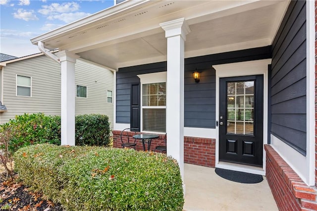 entrance to property featuring brick siding and a porch