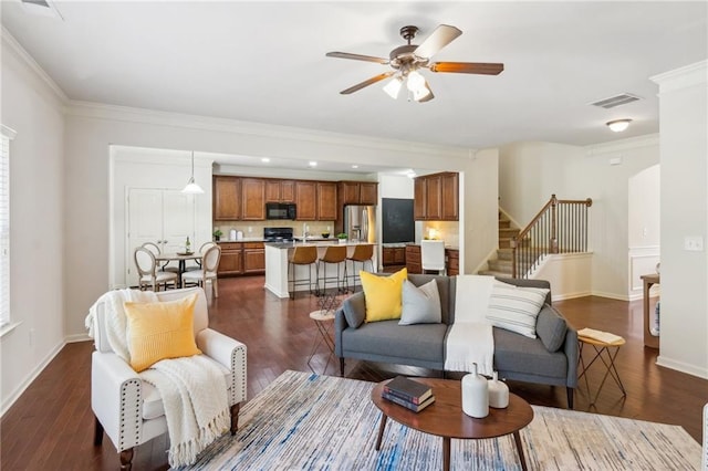 living room featuring stairs, baseboards, dark wood-style flooring, and ornamental molding