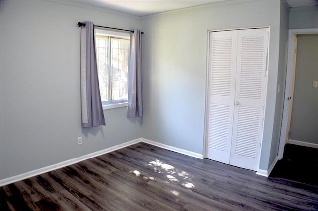 unfurnished bedroom featuring dark hardwood / wood-style flooring, a closet, and ornamental molding