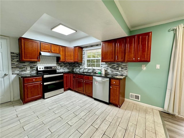 kitchen with stainless steel appliances, sink, light hardwood / wood-style flooring, crown molding, and decorative backsplash