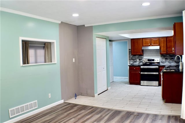 kitchen featuring electric stove, decorative backsplash, sink, crown molding, and light wood-type flooring