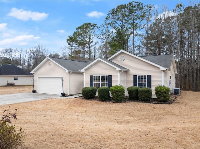 ranch-style home with a garage and central air condition unit