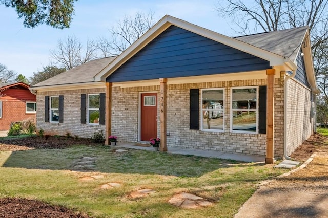 view of front of house featuring a front yard and brick siding