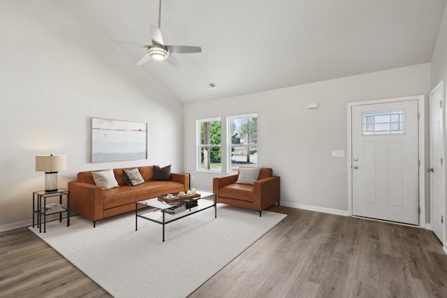 living area featuring lofted ceiling, baseboards, visible vents, and light wood finished floors