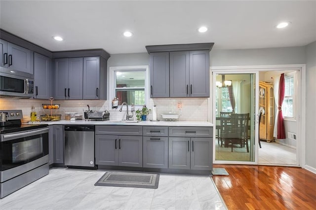 kitchen featuring stainless steel appliances, sink, a wealth of natural light, and gray cabinets