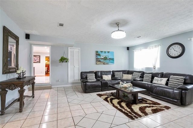 living room featuring a textured ceiling and light tile patterned floors