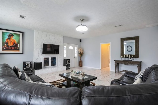 living room featuring a fireplace, a textured ceiling, and light tile patterned flooring