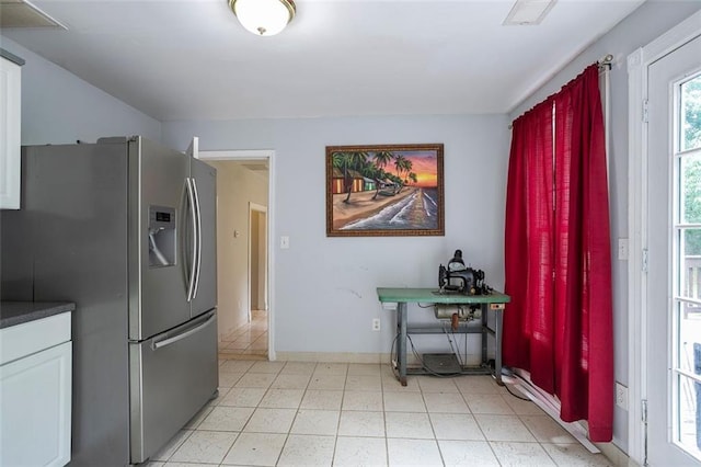 kitchen with stainless steel fridge and white cabinets