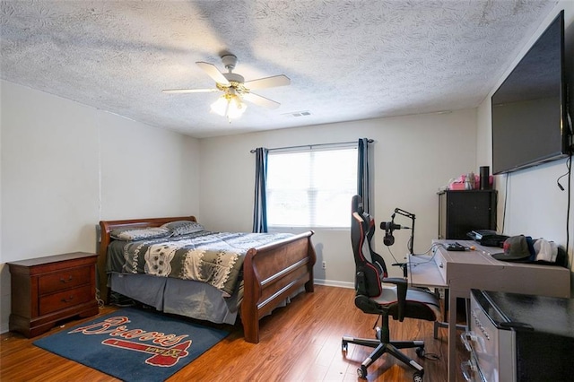 bedroom featuring ceiling fan, a textured ceiling, and light wood-type flooring