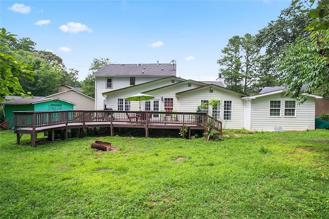 rear view of house with a wooden deck and a yard