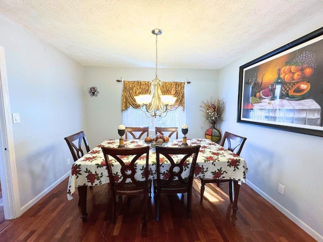 dining area featuring dark wood-type flooring, a chandelier, and a textured ceiling