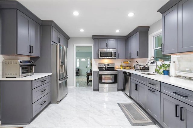 kitchen featuring sink, gray cabinets, and stainless steel appliances