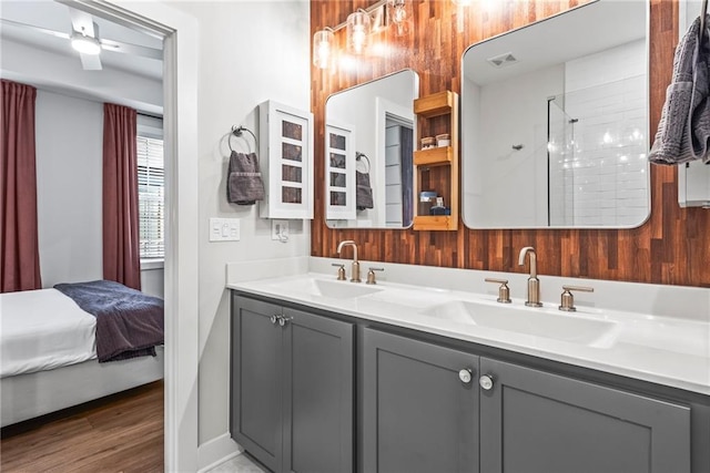 bathroom with hardwood / wood-style floors, vanity, and tiled shower