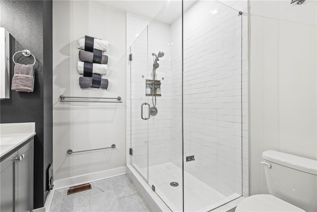 bathroom featuring tile patterned flooring, vanity, toilet, and an enclosed shower