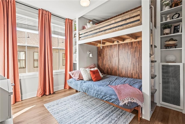 bedroom with wood-type flooring and radiator heating unit