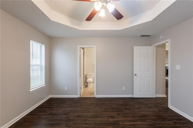 unfurnished bedroom with baseboards, wood finished floors, and visible vents