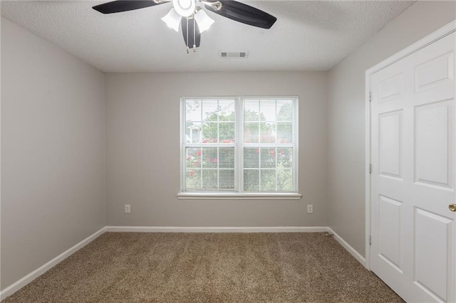 carpeted empty room featuring baseboards, a ceiling fan, a textured ceiling, and visible vents