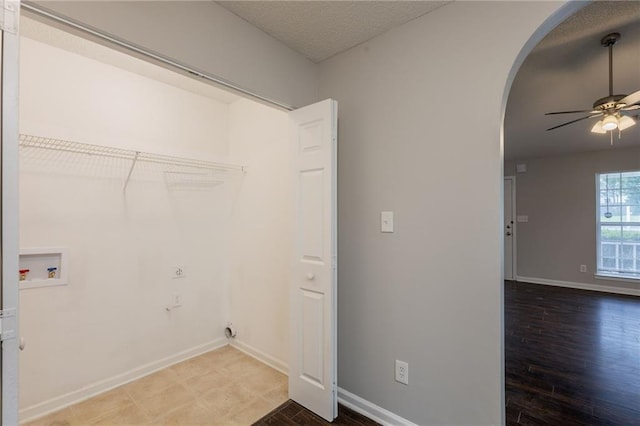 washroom featuring arched walkways, baseboards, laundry area, and a ceiling fan
