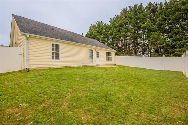 back of house with a fenced backyard, a patio, and a lawn