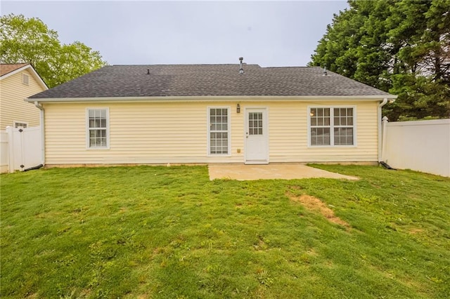 rear view of house with a fenced backyard, a patio, and a lawn