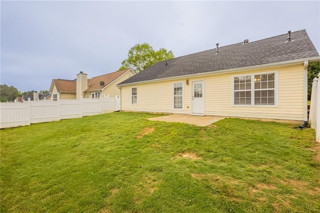 rear view of property featuring fence, a lawn, and a patio area