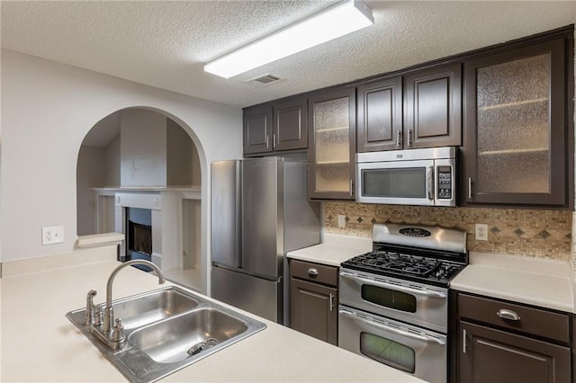 kitchen featuring a sink, appliances with stainless steel finishes, backsplash, and light countertops