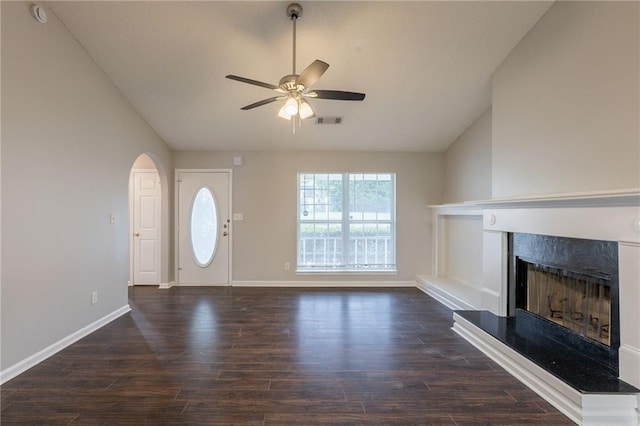 unfurnished living room featuring ceiling fan, visible vents, vaulted ceiling, dark wood finished floors, and a premium fireplace