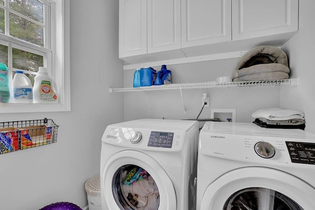 washroom with washing machine and dryer and cabinet space