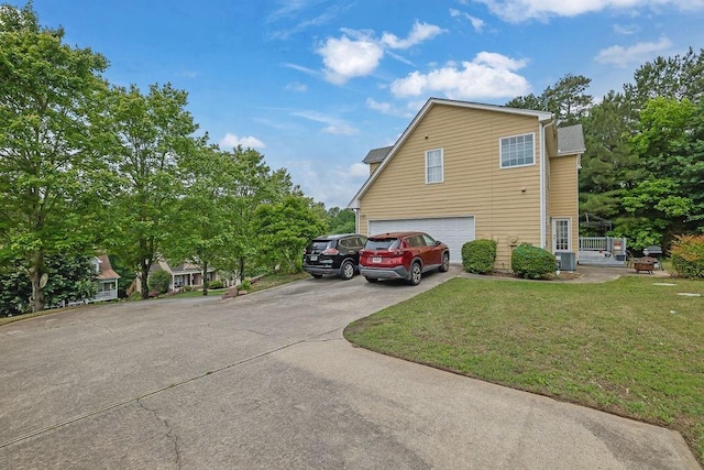 view of side of home with an attached garage, a yard, and concrete driveway