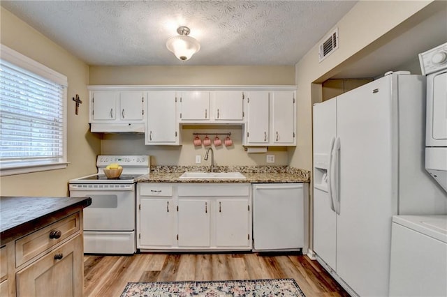 6700 Roswell Rd Unit 22B, Atlanta, GA 30328 - kitchen with white appliances, a sink, light wood-style floors, white cabinets, and a textured ceiling