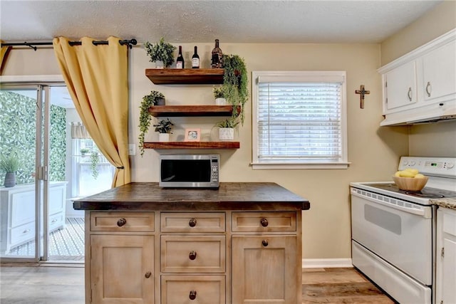 6700 Roswell Rd Unit 22B, Atlanta, GA 30328 - kitchen featuring white range with electric stovetop, stainless steel microwave, under cabinet range hood, light wood-style flooring, and dark countertops