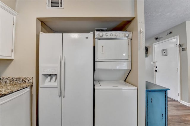 6700 Roswell Rd Unit 22B, Atlanta, GA 30328 - laundry area with stacked washing machine and dryer and wood finished floors