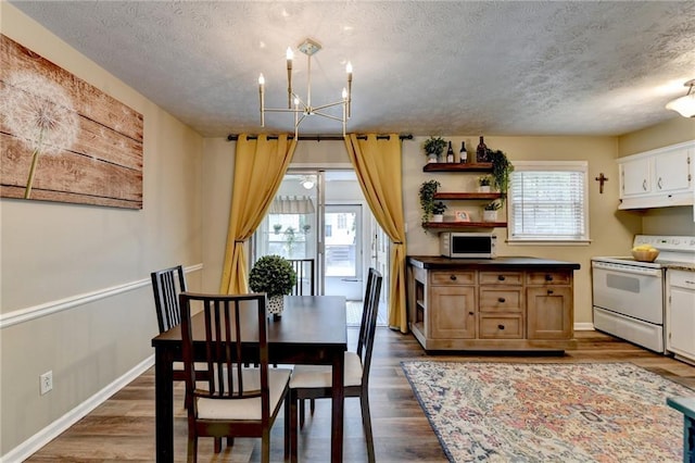 6700 Roswell Rd Unit 22B, Atlanta, GA 30328 - dining area featuring a chandelier, a textured ceiling, dark wood-style flooring, and baseboards