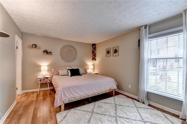 6700 Roswell Rd Unit 22B, Atlanta, GA 30328 - bedroom featuring multiple windows, wood finished floors, a textured ceiling, and baseboards