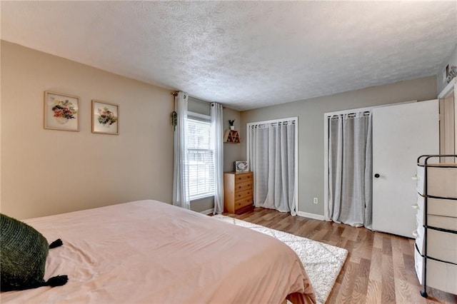 6700 Roswell Rd Unit 22B, Atlanta, GA 30328 - bedroom featuring wood finished floors, a textured ceiling, and baseboards