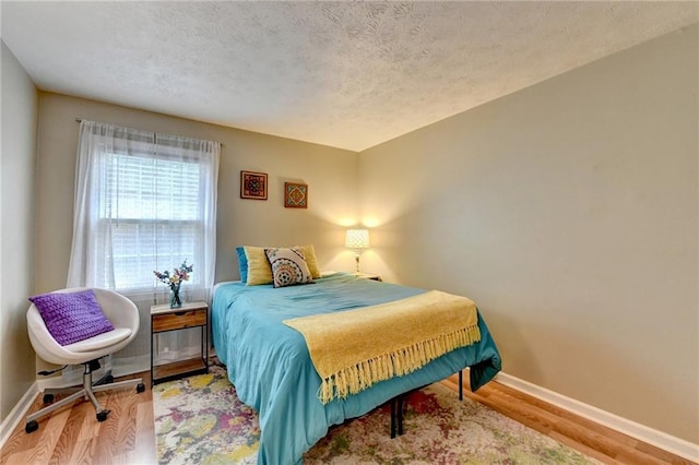 6700 Roswell Rd Unit 22B, Atlanta, GA 30328 - bedroom with baseboards, wood finished floors, and a textured ceiling