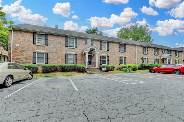 6700 Roswell Rd Unit 22B, Atlanta, GA 30328 - view of front of house featuring uncovered parking, brick siding, and a chimney