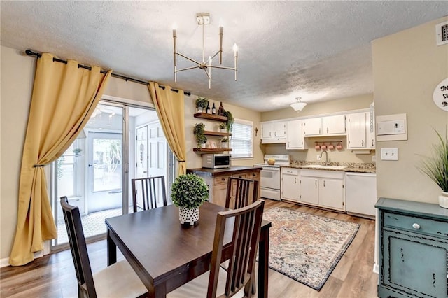 6700 Roswell Rd Unit 22B, Atlanta, GA 30328 - dining space featuring a chandelier, a textured ceiling, and light wood-type flooring