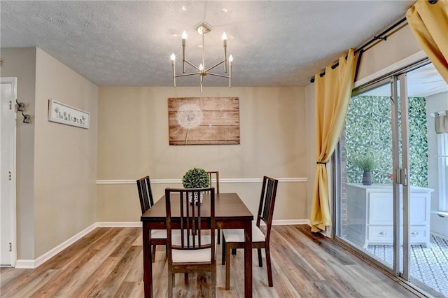 6700 Roswell Rd Unit 22B, Atlanta, GA 30328 - dining room featuring light wood-type flooring, a chandelier, baseboards, and a textured ceiling