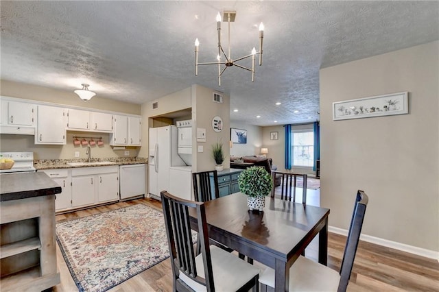 6700 Roswell Rd Unit 22B, Atlanta, GA 30328 - dining area featuring a textured ceiling, a chandelier, light wood-type flooring, baseboards, and recessed lighting