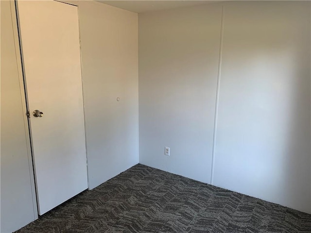 unfurnished bedroom featuring dark colored carpet