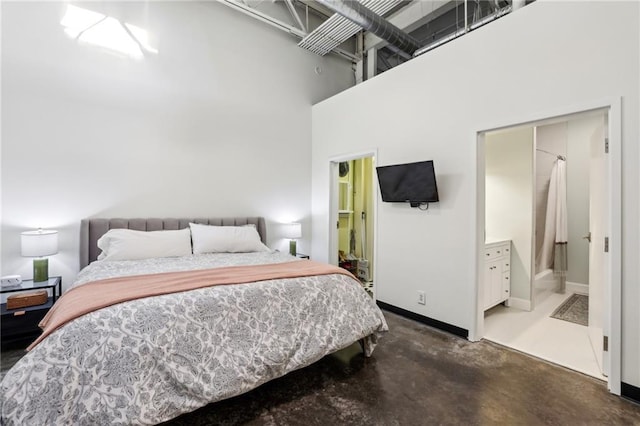 bedroom featuring connected bathroom and a towering ceiling