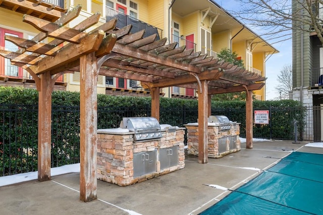 view of patio featuring an outdoor kitchen, grilling area, and a pergola