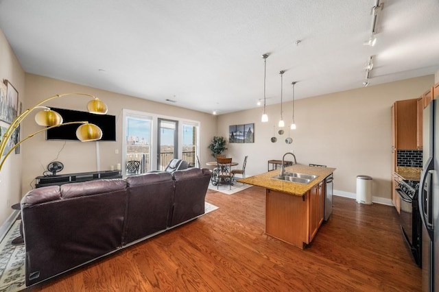 kitchen with sink, stainless steel dishwasher, light stone countertops, a center island with sink, and dark hardwood / wood-style flooring